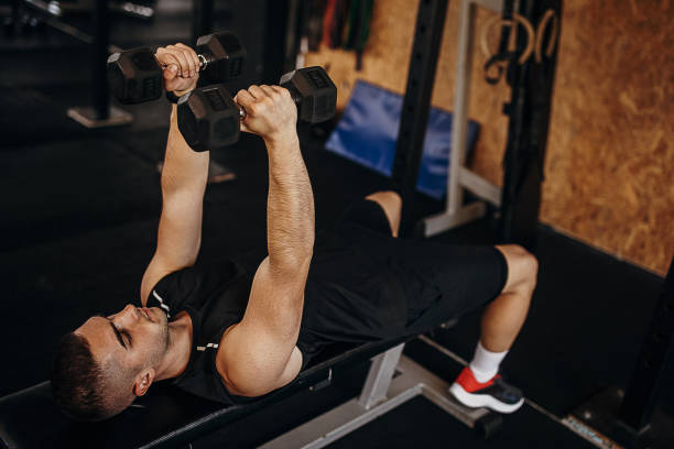 istock Man training with dumbbells in gym 1343189558