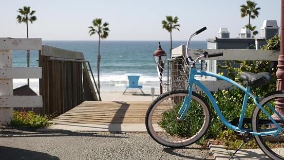 Bicicleta crucero en bicicleta por la playa del océano, costa de California EE.UU. Ciclo de verano, escaleras y palmeras. photo