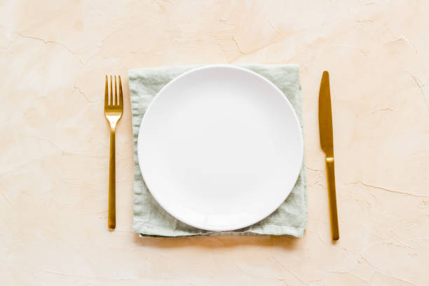 istock Dinner plate setting with cutlery and napkin. Top view 1343189931