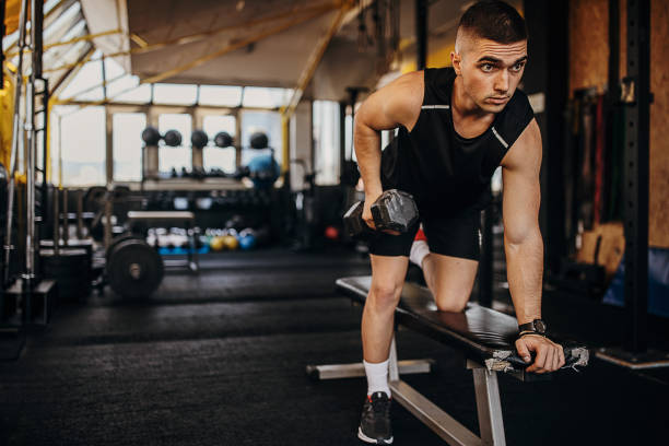 entrenamiento de hombre en forma con mancuerna en gimnasio - weight training weight bench weightlifting men fotografías e imágenes de stock