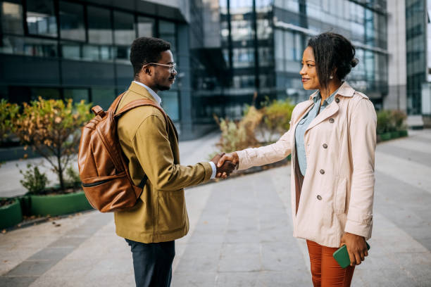 istock Colleagues shaking hands in front of their company 1343190161