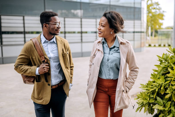istock Happy colleagues having a casual conversation while walking in front of their company 1343190449