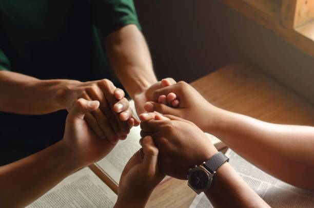 A group of young people holding hands in prayer according to God's faith in Christianity A group of young people holding hands in prayer according to God's faith in Christianity domestic staff stock pictures, royalty-free photos & images