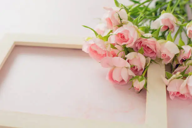 Pink roses on pink marble surface next to white keyboard