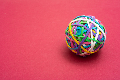 elastic or rubber bands in a ball on a pink background ,office ssupply or concept of flexibility .