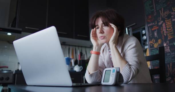 istock Mature woman is taking her blood pressure while working at home office 1343197243