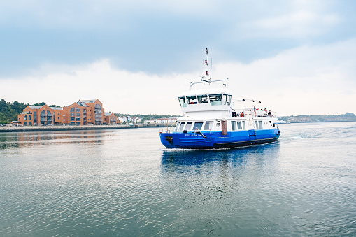 North Shields, England - September, 06 2021: Spirit of the Tyne passenger ferry about to dock at North Shields Ferry landing on the Tyne River, Tyne and Wear, England on an early autumn morning.