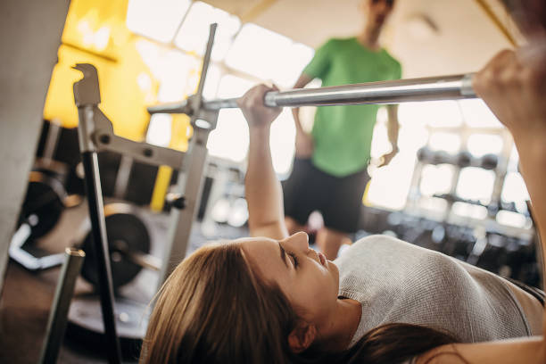 istock Fitness trainer watching a woman doing bench press 1343218767