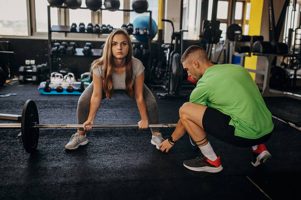 istock Personal trainer assisting a woman in deadlift 1343218857