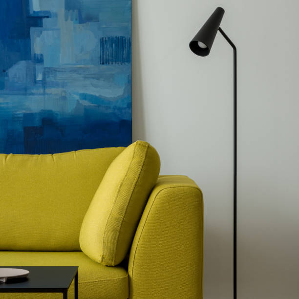 istock Yellow couch, black lamp and art, close-up 1343219007