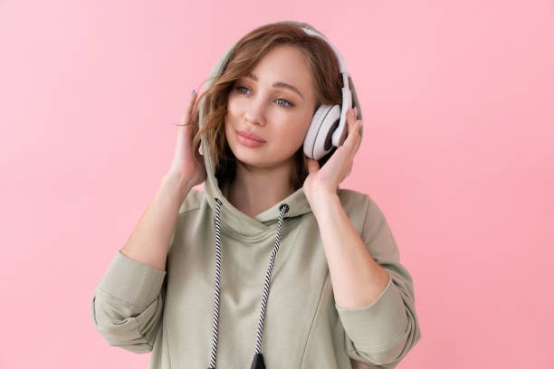 donna ascolta musica cuffie rosa sfondo studio sparare - dj stand foto e immagini stock