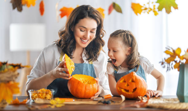 famiglia che si prepara per halloween - halloween pumpkin party carving foto e immagini stock