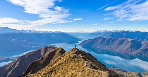 Photo of Asian traveler celebrating success at Roy's Peak Lake Wanaka New Zealand