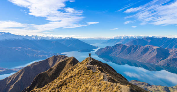 young asian couple celebrating success at roy's peak lake wanaka new zealand - nature travel locations imagens e fotografias de stock