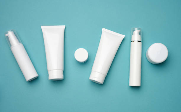 istock jar, bottle and empty white plastic tubes for cosmetics on a blue background. Packaging for cream, gel, serum, advertising and product promotion, mock up 1343238717