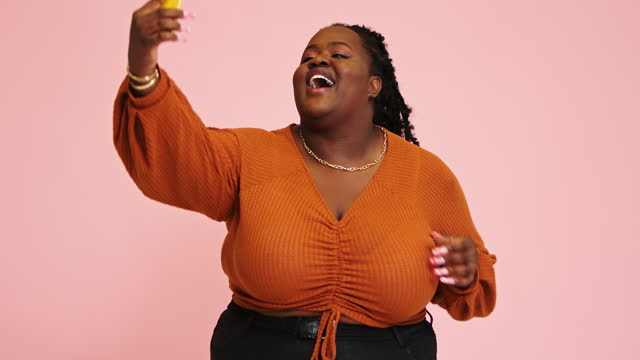Afro-American plump lady makes selfie changing positions