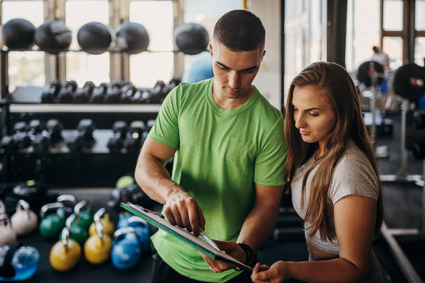 Personal trainer and young woman in gym