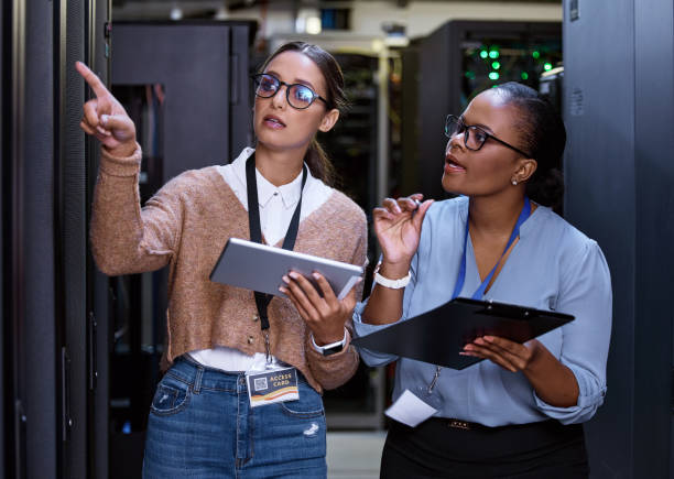 istock Cropped shot of two attractive young female computer programmers working together in a server room 1343240862