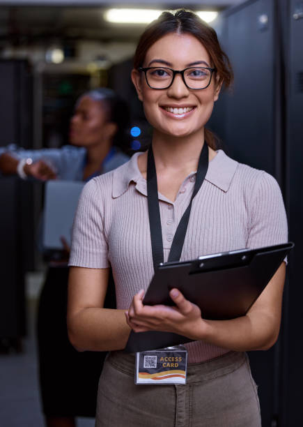 istock Cropped portrait of an attractive young female programmer working in a server room with her colleague in the background 1343240865