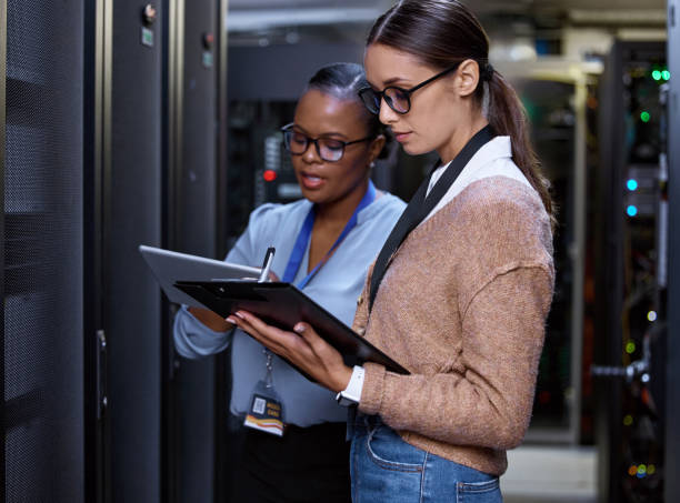 istock Cropped shot of two attractive young female computer programmers working together in a server room 1343240869