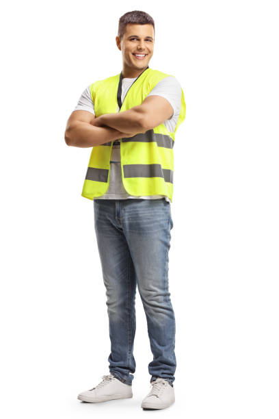 Full length portrait of a smiling security officer in a safety vest standing with crossed arms Full length portrait of a smiling security officer in a safety vest standing with crossed arms isolated on white background waistcoat stock pictures, royalty-free photos & images