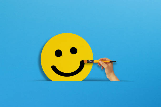 istock Hand holding a brush draws a happy smiley face emoticon 1343244293