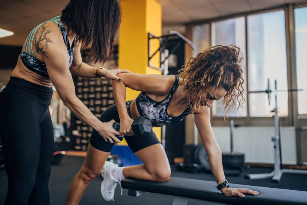 istock Personal trainer assisting a woman in training 1343260210