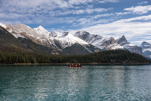 Tourists canoeing into the Spirit Island with Canadian Rockies on Maligne lake at Jasper national park, AB, Canada