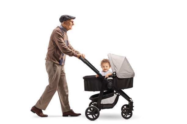 pełnowymiarowe ujęcie profilu starszego emeryta chodzącego i pchającego wózek spacerowy - grandfather baby grandson grandparent zdjęcia i obrazy z banku zdjęć