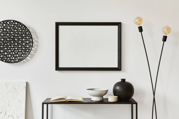 istock Minimalistic stylish composition of creative room interior design with mock up poster frame, metal shelf, industrial lamp and personal accessories. Black and white concept. Template. 1343263369