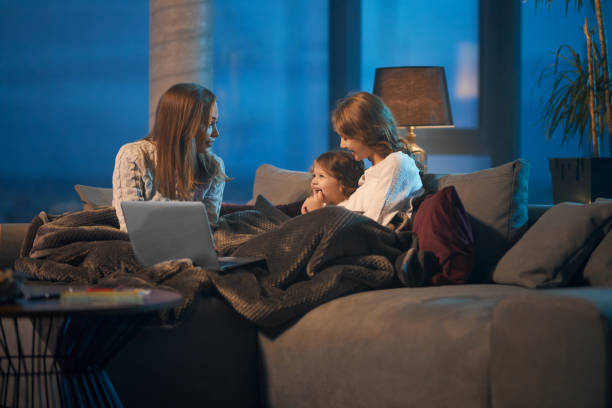 istock Happy mother and two daughters using laptop at home 1343265010