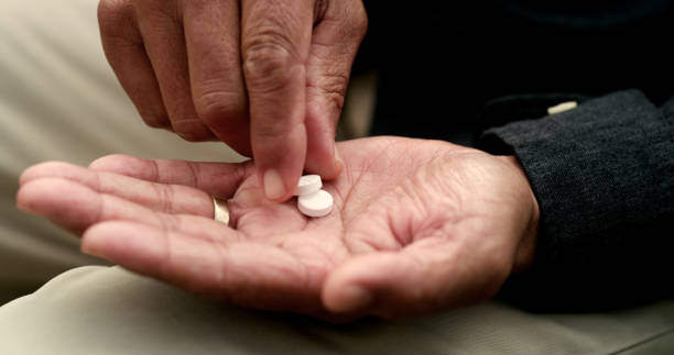 Shot of an unrecognizable man taking tablets in a garden