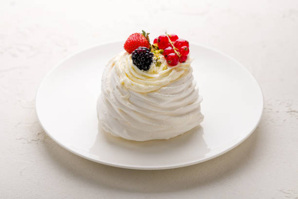 istock dessert Anna Pavlova with berries on white plate on white concrete table 1343267658
