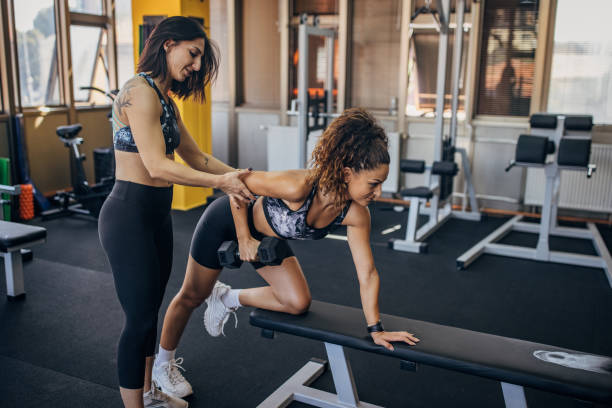 istock Personal trainer assisting a woman in training 1343267787