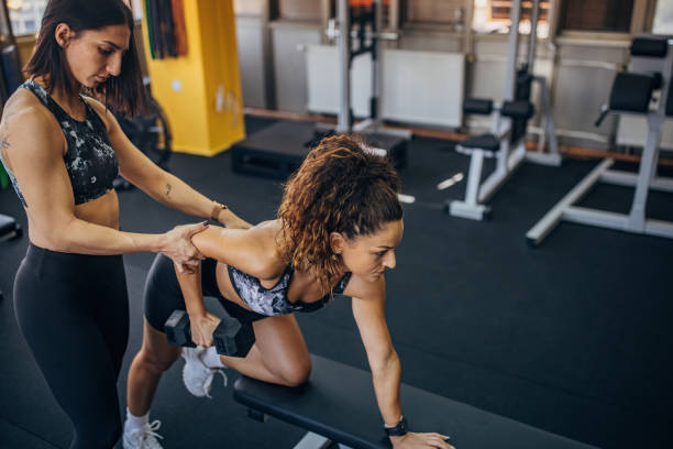 istock Personal trainer assisting a woman in training 1343267819