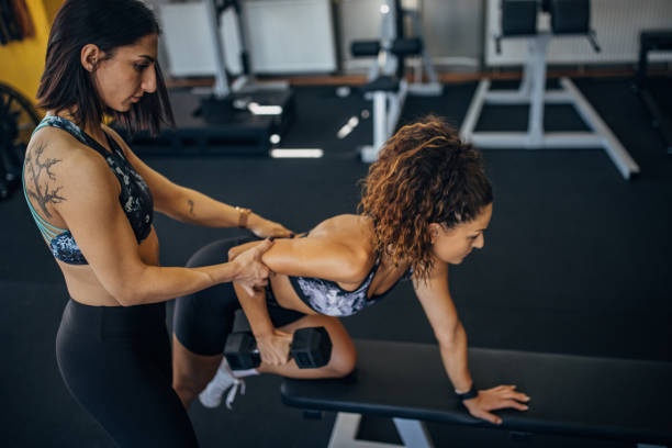 istock Personal trainer assisting a woman in training 1343267845