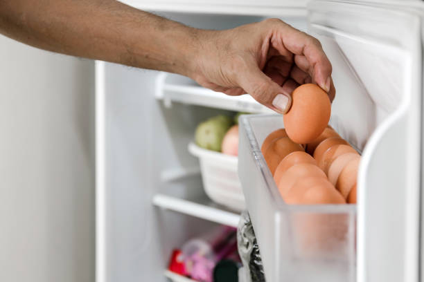 istock human hands put chicken eggs in the egg-laying compartment in the refrigerator. 1343268234
