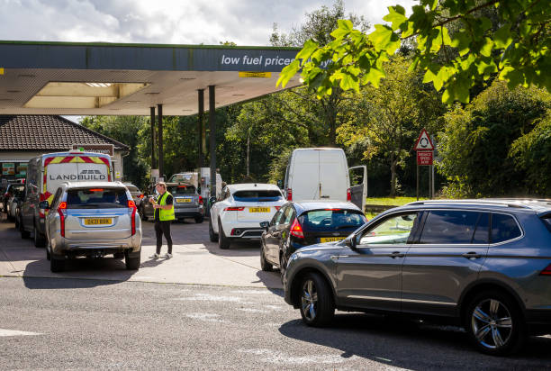 Cars queuing for petrol at gas station due to fuel shortage Crawley, UK - 27 September, 2021: cars queue up to fill up with petrol at the gas station during a fuel shortage. Cars are lined up down the road as people rush to panic buy petrol. traffic car traffic jam uk stock pictures, royalty-free photos & images