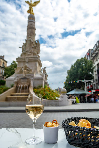 Drinking of brut champagne sparkling wine in street cafe in old central part of city Reims, Champagne, France Drinking of brut champagne sparkling wine in street cafe with view on old central part of city Reims, Champagne, France cramant stock pictures, royalty-free photos & images