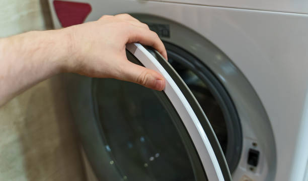 istock Man opening door of washing machine. 1343270231