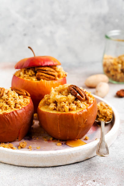 istock Baked Apples Stuffed with pecans, cinnamon, streyzel and honey on old concrete light background. Rustic stale 1343275240