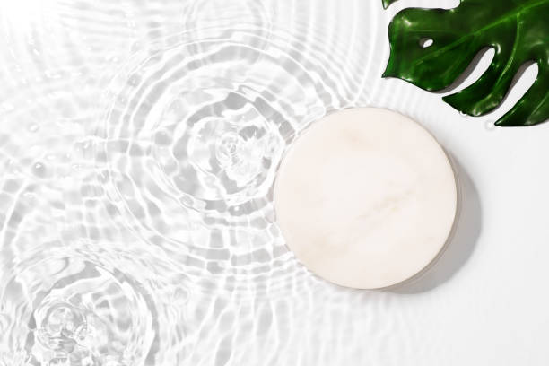 istock Transparent and clean white water background with podium and sunlight reflection 1343275813