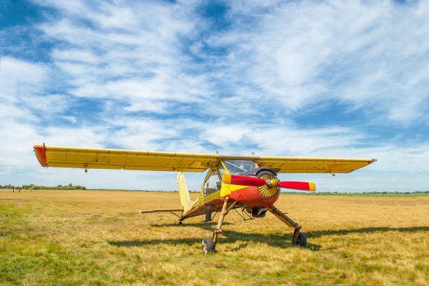 kleines altes gelbes und rotes flugzeug, das in der sommerfeldfrontansicht steht - crop sprayer front or back yard pest control equipment spraying stock-fotos und bilder