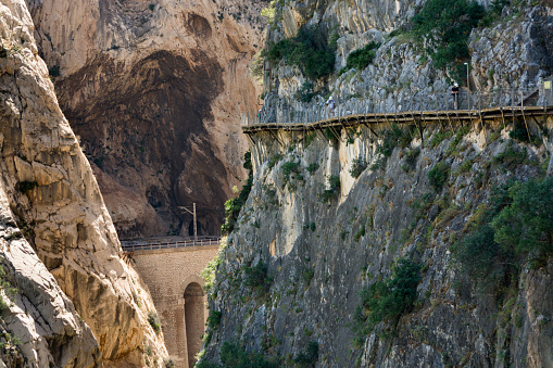 Hikers walk on the footbridge that overlooks the vertiginous and narrow canyon of the Gaitanes gorges