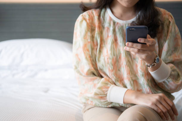istock Woman tourist using smartphone while sitting on the bed. 1343282681