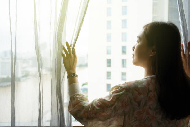 istock Woman opening the window curtain. 1343283432