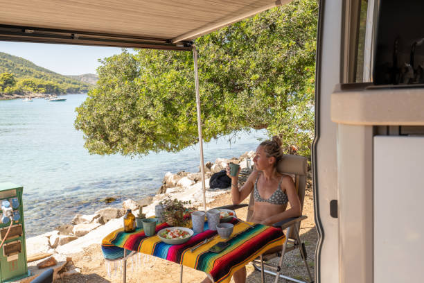 istock Woman enjoys lunch in her van, beach view 1343291567