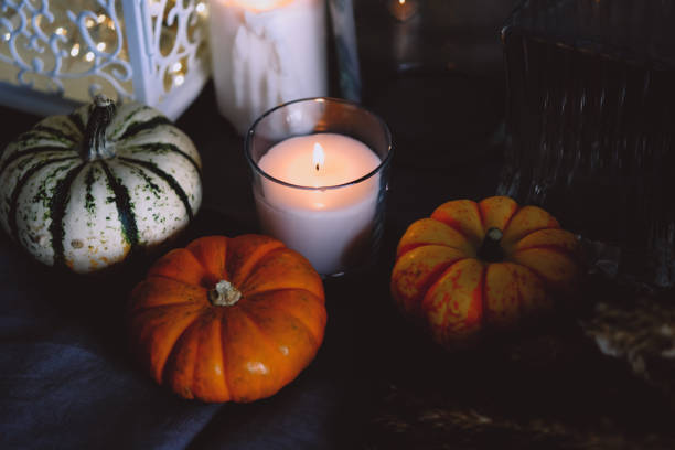 istock Cozy autumn home decor with candles and pumpking. 1343291987