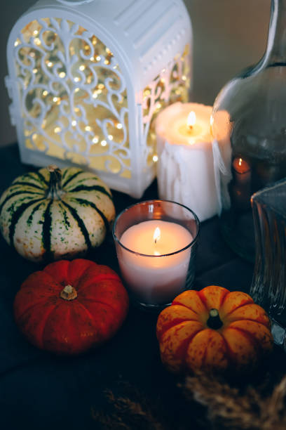 istock Cozy autumn home decor with candles and pumpking. 1343291990