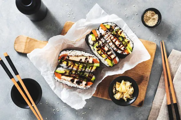 Photo of onigirazu sushi sandwich with vegan tofu filling marinated with soy sauce, sweet potatoes and avocado